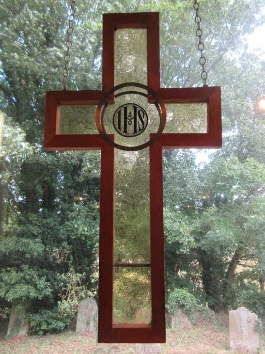 A wooden cross with stained glass, in a Legbourne Woldmarsh churchyard